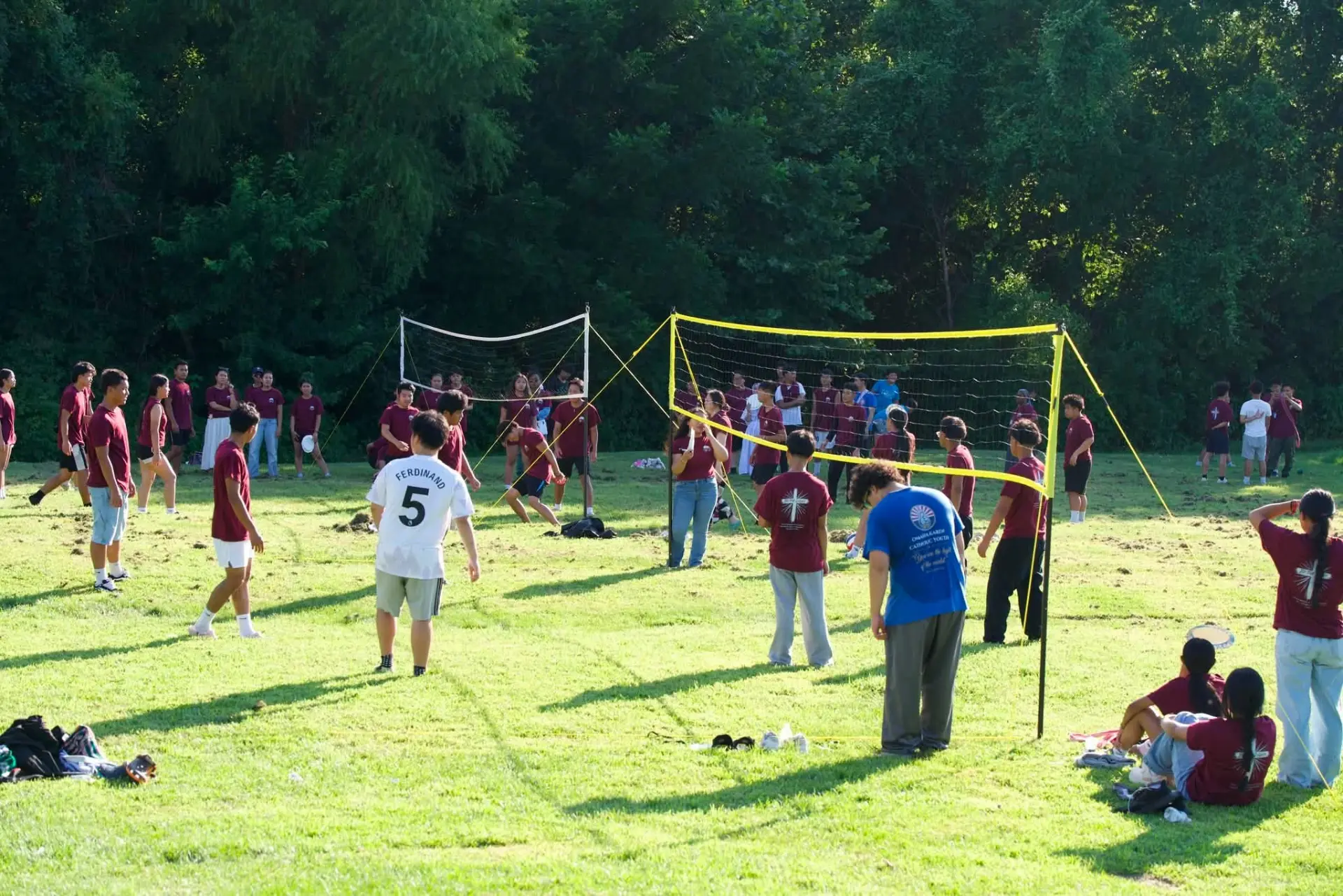 KACC youth and families playing volleyball together on a sunny field